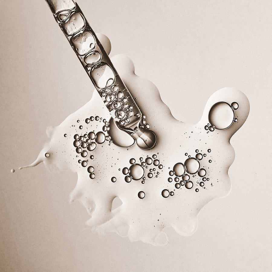 Super Glue+ dropper with clear serum droplets showing the peptide serum's texture